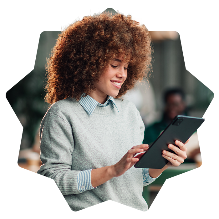 Mujer joven sonriendo mientras utiliza una tablet