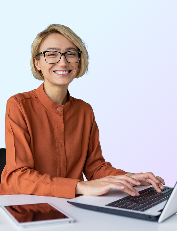 woman smiling while working on a laptop