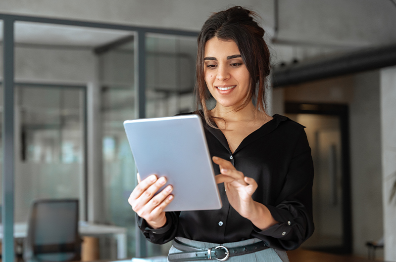 Mujer de negocios sonriente trabajando con una tableta