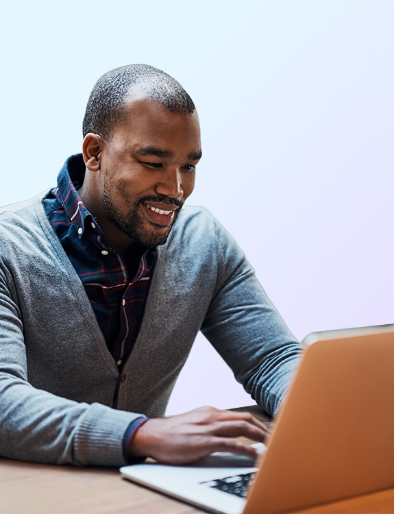 man smiling while working on a laptop