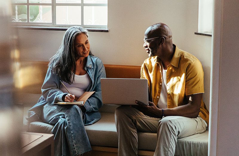 Compañeros colaborando en un proyecto usando un portátil.