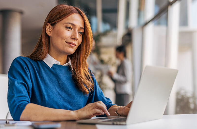 Mujer de negocios utilizando un ordenador portátil con Gemini Enterprise en una oficina