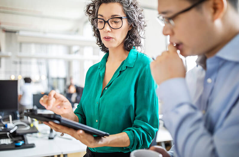 Sesión de planificación tecnológica con una tablet durante una reunión dinámica al aire libre.