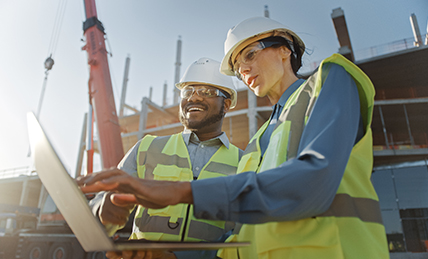 Construction workers looking at a laptop