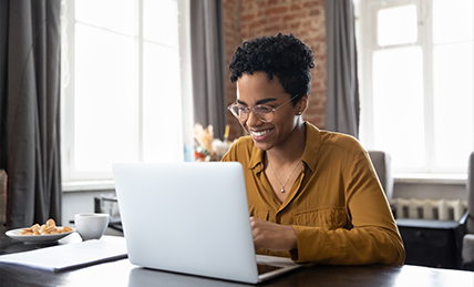 Woman smiling while working on a laptop