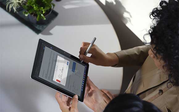 Een vrouw werkt met  ee Surface Go 3 en Adobe Sign